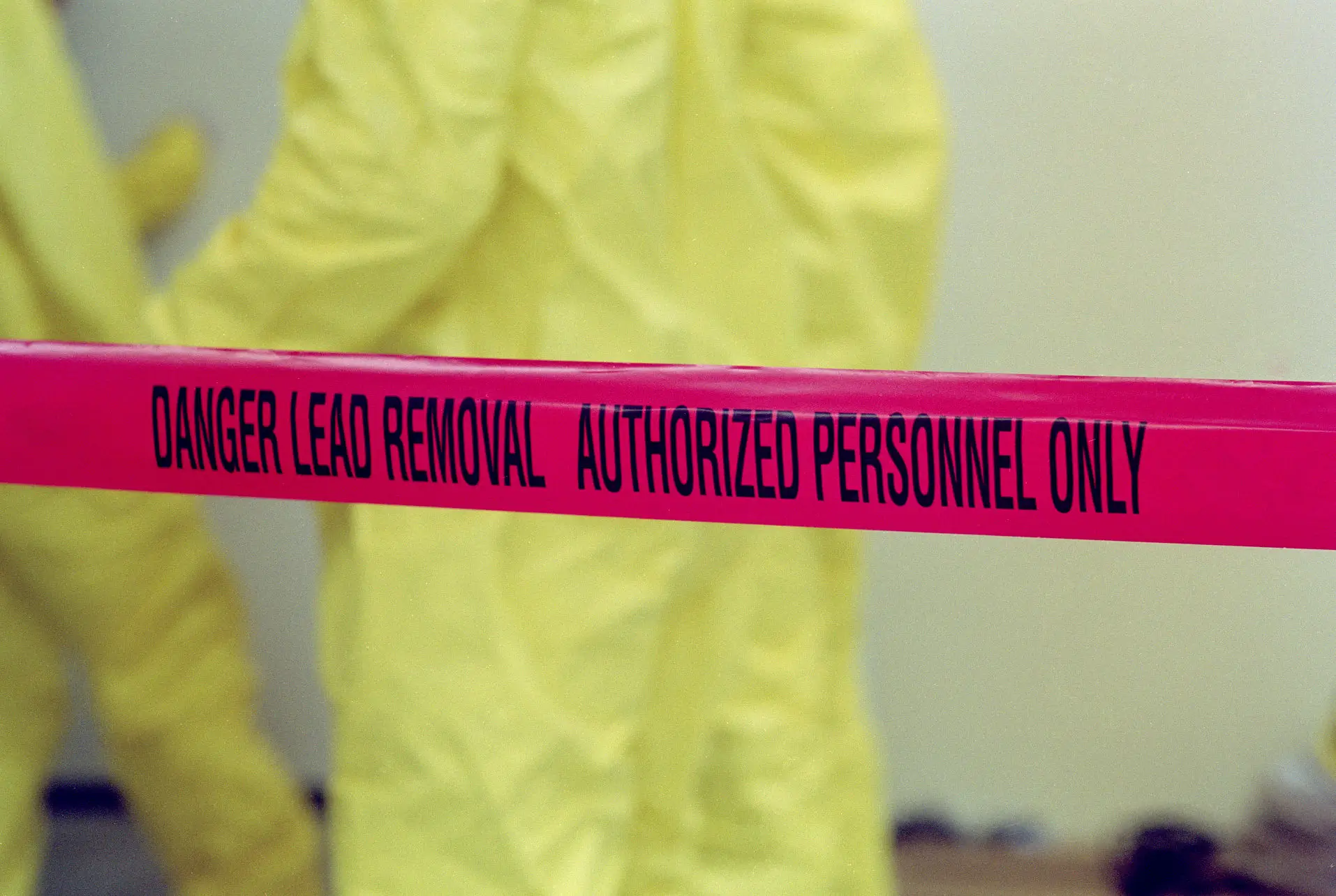 Danger lead removal tape and yellow suits.