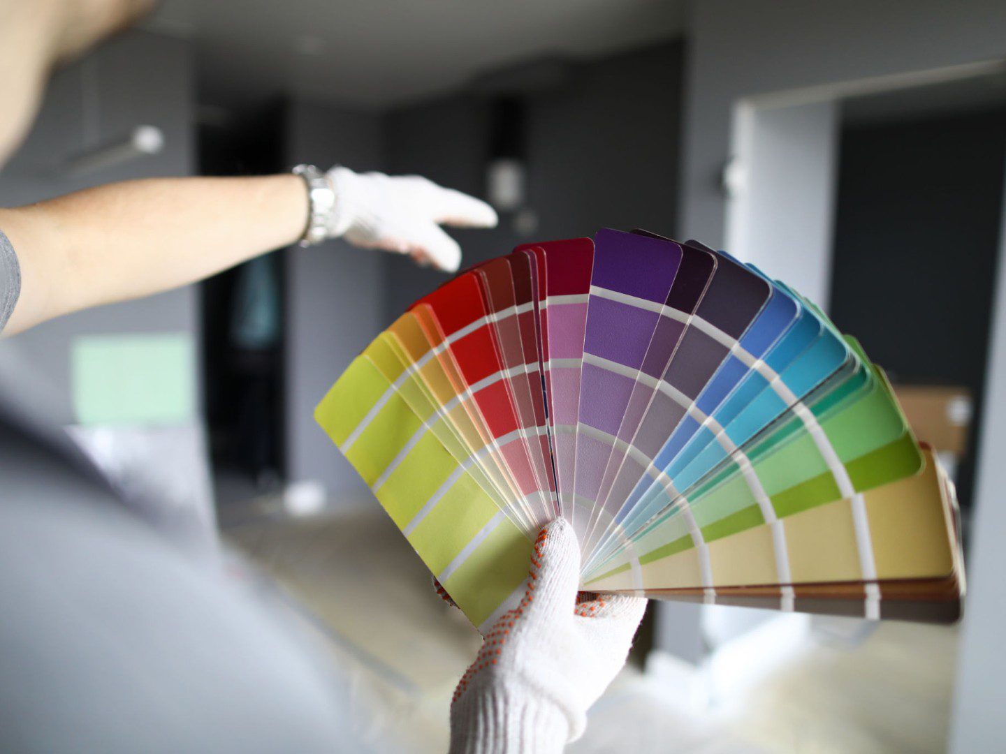 Person holding colorful paint swatch fan.