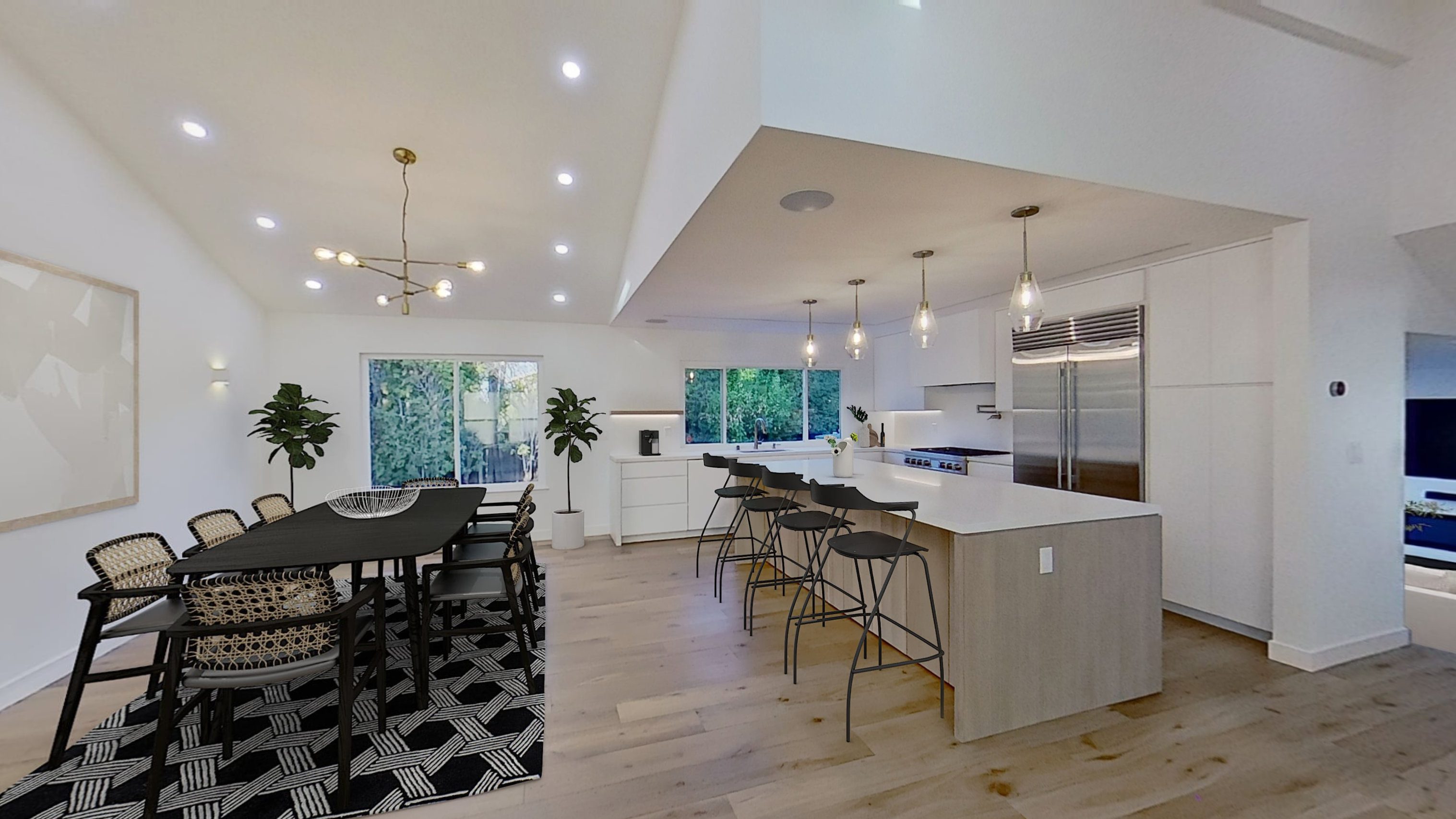 Modern open kitchen and dining area with pendant lights.