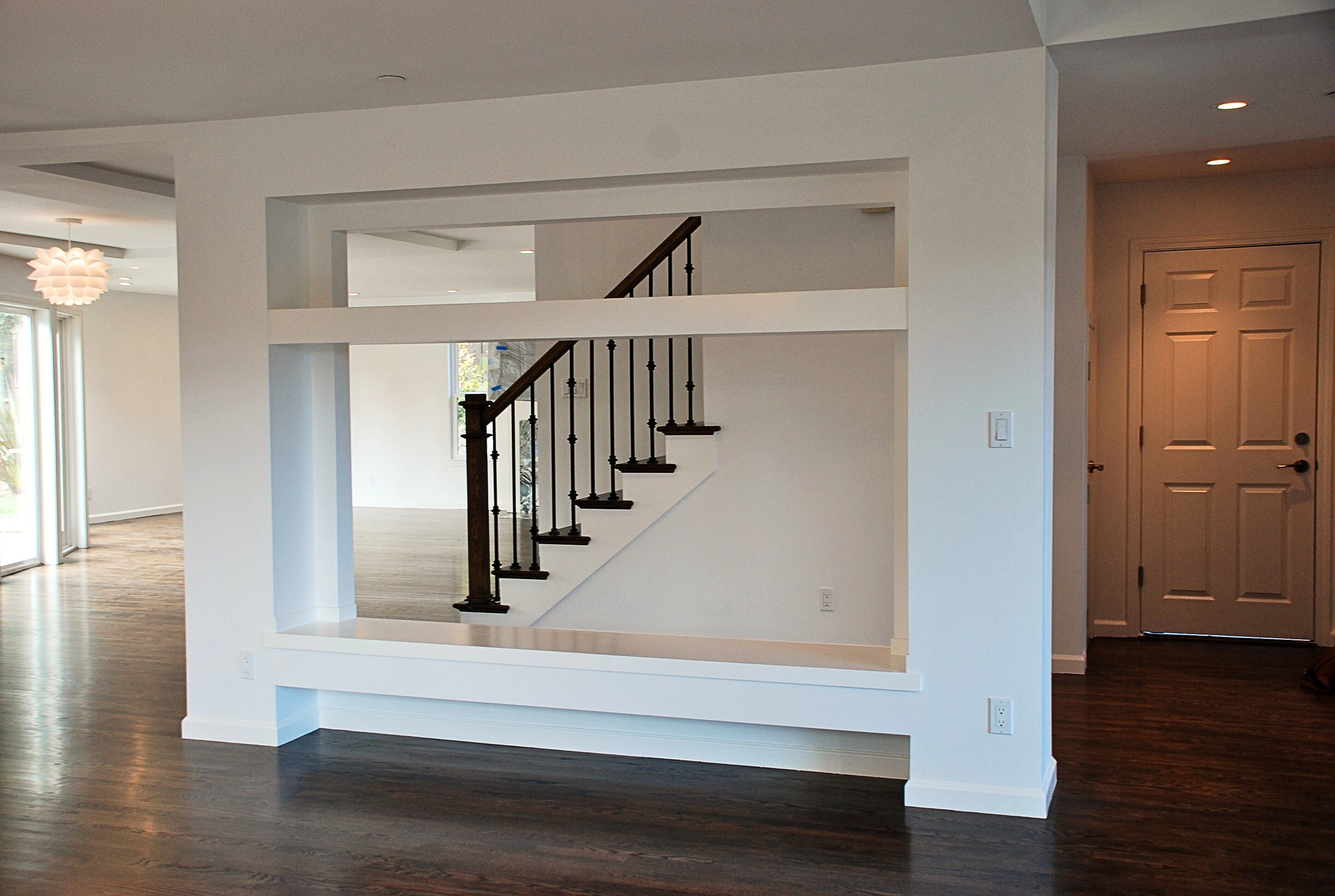 Modern open wall design with a built-in bench and view of staircase.